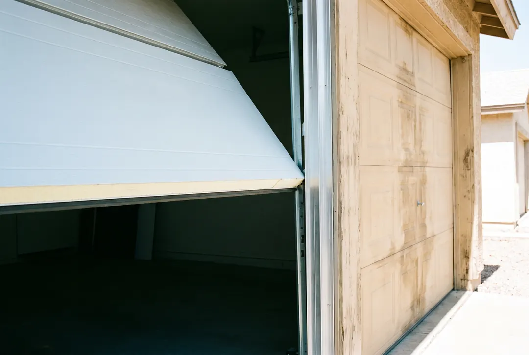 A new insulated steel door section going in beside an older weathered one