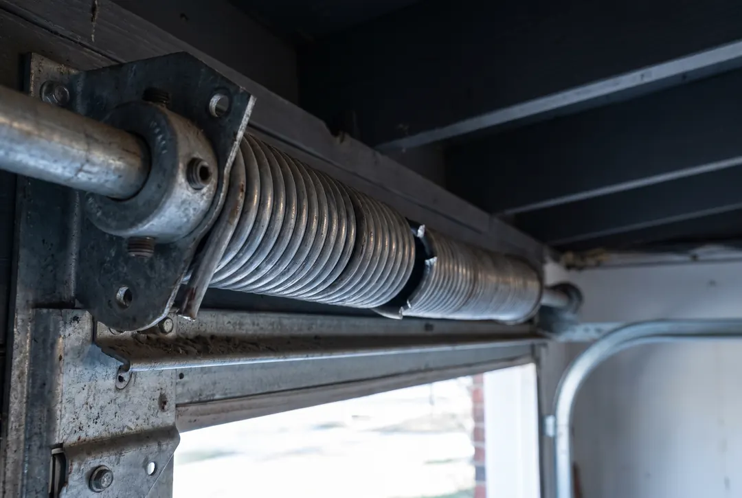 Broken torsion spring above a garage door, the coil separated at the break